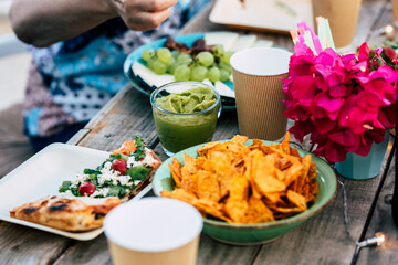 Close up of table full of colorful mexican food like nachos and guacamole or pizza - concept of...