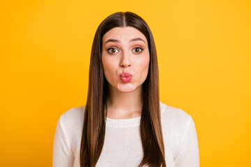 Portrait of adorable carefree young girl kiss lips look camera isolated on vivid yellow color background