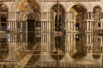 St. Mark's Basilica reflecting in high water flooded St. Mark's Square at night, Venice, Italy