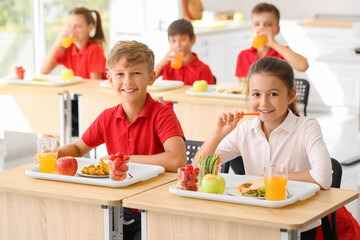 Pupils having healthy lunch in classroom