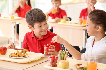 Pupils having healthy lunch in classroom