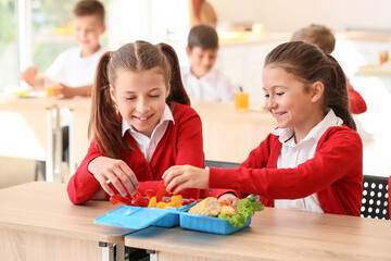 Pupils having healthy lunch in classroom