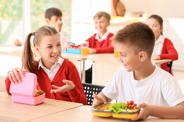 Pupils having healthy lunch in classroom