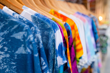 A rack of colorful shirts hanged for sale at local market.
