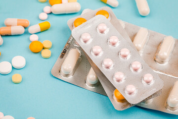 A bunch of pills on a blue background. The concept of healthcare