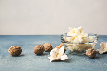 Bowl with shea butter and nuts on table