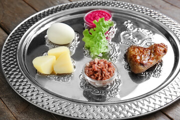 Passover Seder plate with traditional food on table, closeup