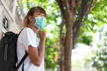 Young Asian woman wear surgical protection face mask in the city, COVID-19 concept