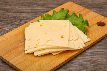 Sliced yellow cheese over board