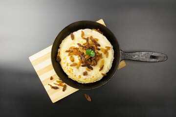 Top view of a pan with pancakes garnished with raisins.