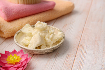 Plate with shea butter and bathing supplies on table