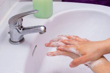Someone washing their hands with soap.