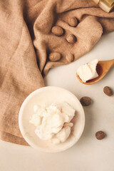 Plate with shea butter and nuts on light background