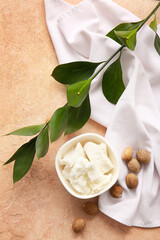 Bowl with shea butter on color background