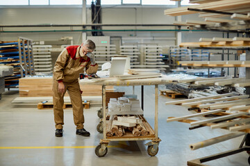 Exhausted carpenter having a headache while working at workshop during coronavirus pandemic.