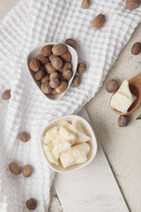 Shea butter with nuts on light background