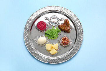 Passover Seder plate with traditional food on color background