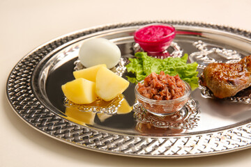 Passover Seder plate with traditional food on light background, closeup