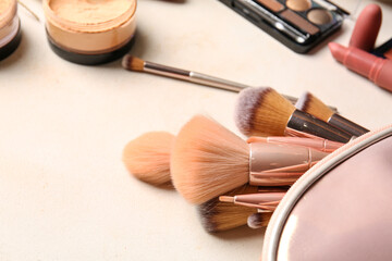 Bag with makeup brushes on table