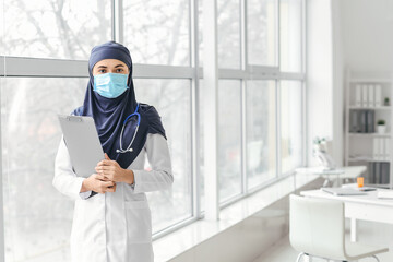 Fototapeta na wymiar Portrait of female Muslim doctor wearing protective mask in clinic