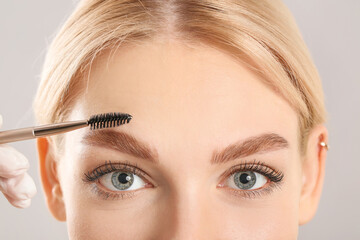 Naklejka premium Young woman undergoing eyebrow correction procedure, closeup
