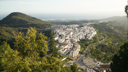 White houses during sunset in Nerja Village, located within a green hill landscape in Andalusia, Spain.