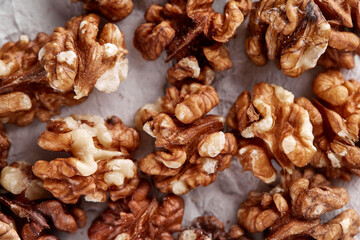 Peeled walnut halves in a pile, isolated on a light gray background, copy the space. Food menu