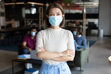 Portrait of asian businesswoman wearing face mask in creative office