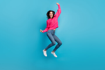 Fototapeta na wymiar Full length portrait of astonished girl jump fists up open mouth shout yes isolated on blue color background