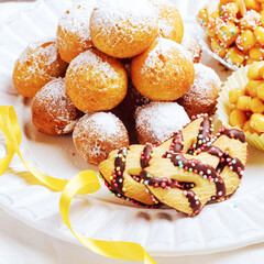 Traditional Carnival Italian fritters dusted sugar with honey and sprinkles.