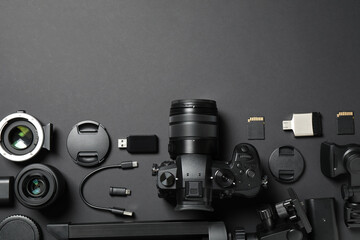 Flat lay composition with camera and video production equipment on black background. Space for text