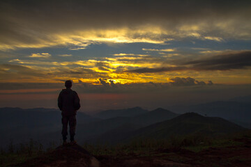 silhouette of a person standing on a mountain top