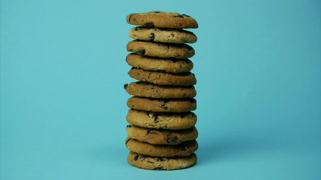 Pile of cookies decreasing and increasing on blue background. Stop motion animation
