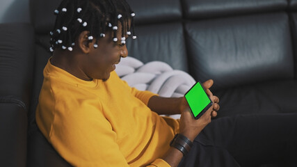 African american black man with dreadlocks watching at the green screen on smartphone. High quality photo
