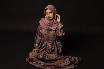 Fashion portrait of young beautiful asian muslim woman with wearing hijab isolated on black background.