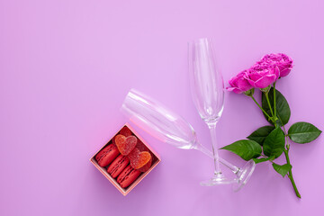 Festive composition for valentine's day and mother's day. Pink rose, gift box with macaroons and glasses.