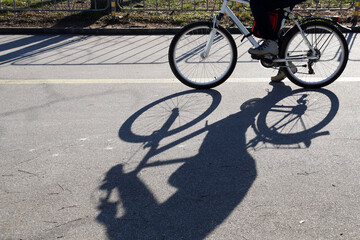 Fototapeta na wymiar the shadow of a riding cyclist on a sunny day