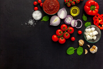 Ingredients for homemade pizza with ingredients sweet basil, tomato, garlic, pepper, onion and mozzarella cheese