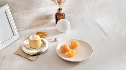 Beauty lifestyle background with Opened Jar of face cream and fresh tangerines.  winter skin care concept