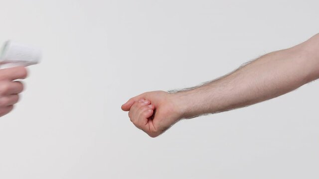 Close up cropped man measuring temperature on hand with electronic thermometer to enter somewhere showing thumb up isolated on white background studio. Advertising area workspace mock up copy space
