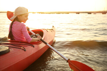 Happy girl kayaking on river. Summer camp activity