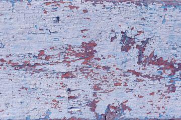 Blue peeling paint on the wall. Old concrete wall with cracked flaking paint. High resolution texture for background