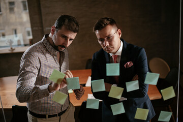 Businessmen in the office. Colleagues in conference room making a business plan. Two man working together on new project.