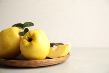 Fresh ripe organic quinces with leaves on light table. Space for text