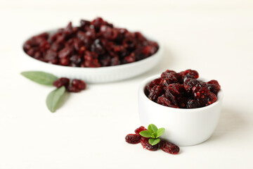 Tasty dried cranberries and leaves on white table. Space for text