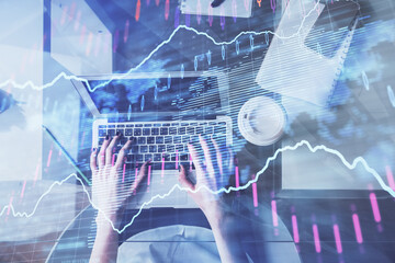 Double exposure of woman hands working on computer and forex chart hologram drawing. Top View....