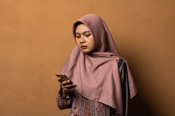 portrait of Asian Woman using smartphone on gold background.