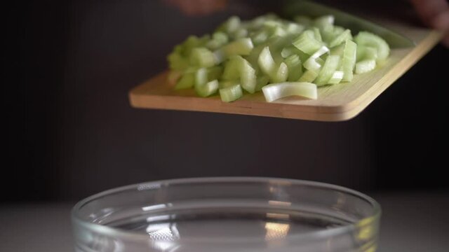 man cutting celery making vegetable salad. healthy food, fresh harvest. celery plants. green celery leaves falling slow motion.
