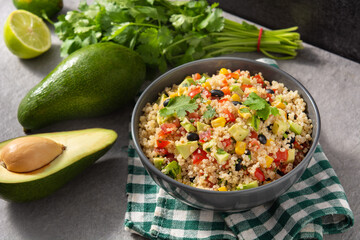Mexican salad with quinoa in bowl on gray stone