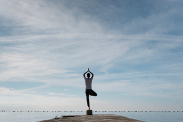 Attractive young man practicing yoga meditation and breathwork outdoors by the sea